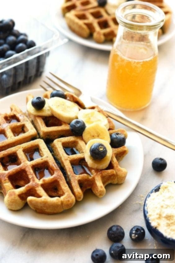 A close-up of a healthy blueberry waffle, showcasing the plump blueberries and golden texture.