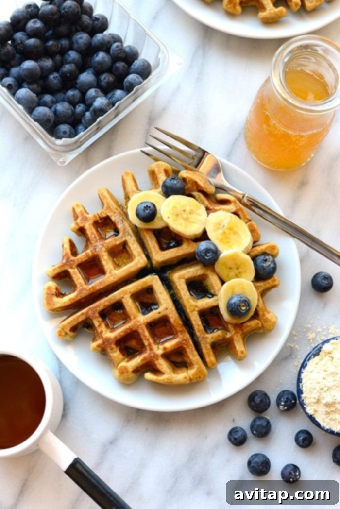 A stack of healthy waffles topped with fresh blueberries and banana slices, a perfect visual for a wholesome meal.