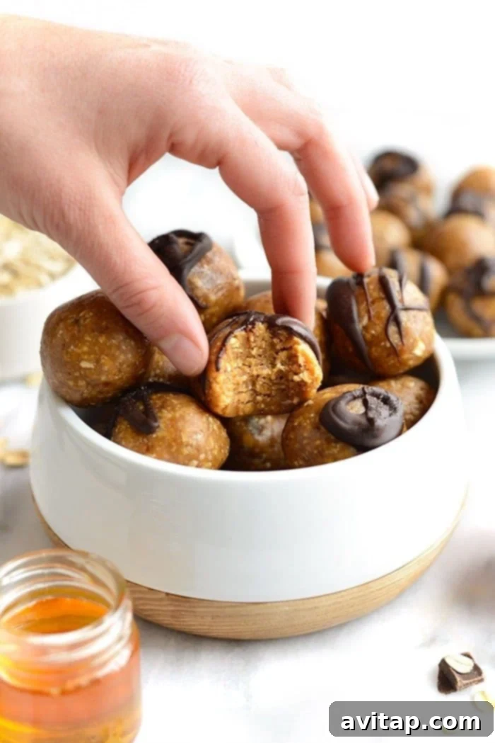 Delicious Peanut Butter Energy Balls: Your Perfect Healthy Snack A hand reaching for a freshly made peanut butter energy ball, highlighting its soft texture and inviting appearance.