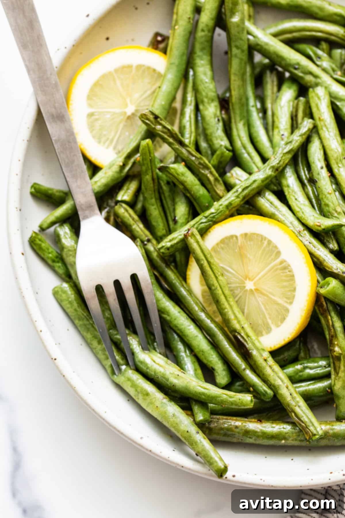 Perfectly roasted green beans presented in an elegant serving dish, highlighting their vibrant color and inviting texture.