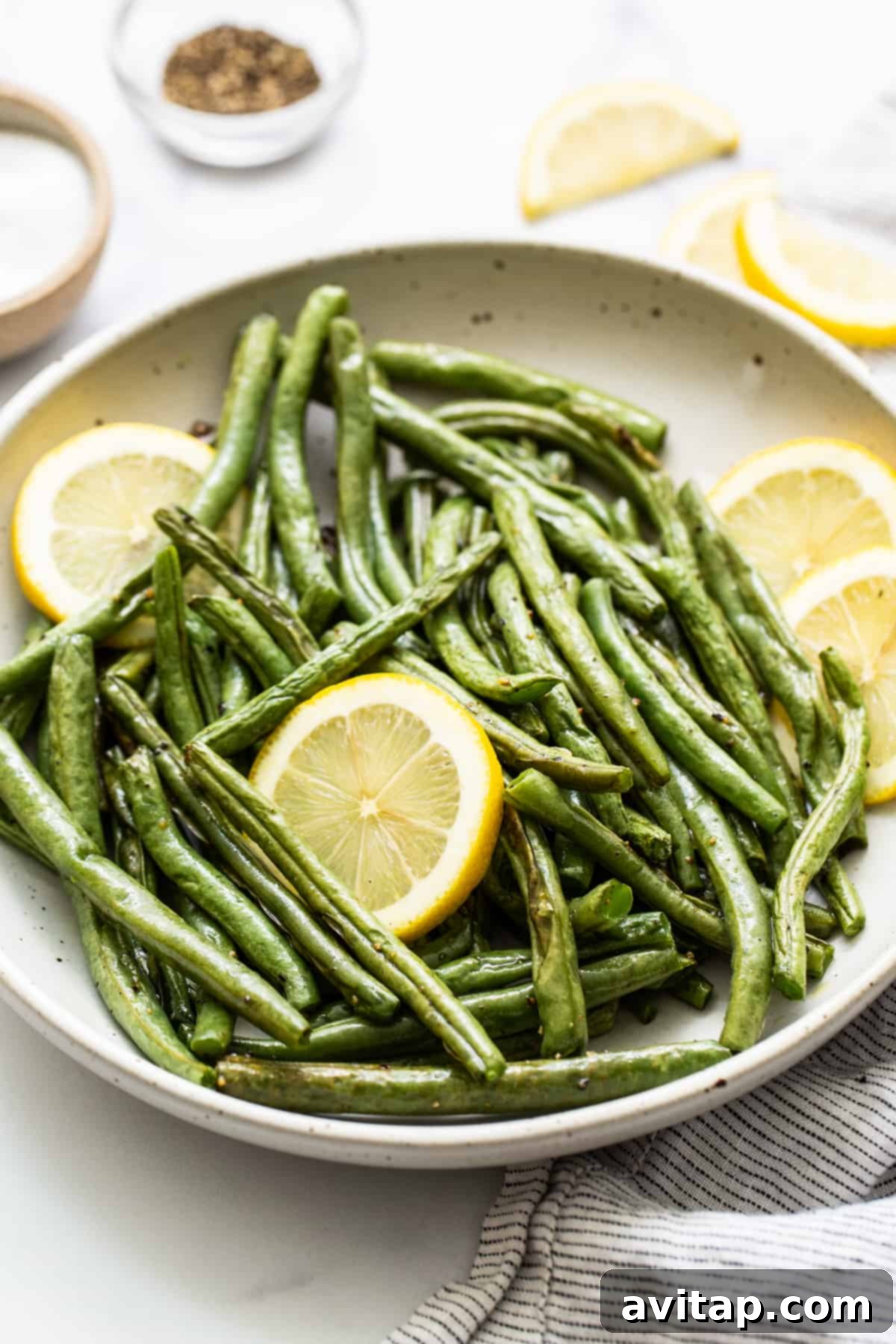 Roasted green beans in a beautifully styled serving dish, perfect for a holiday gathering or any special meal.