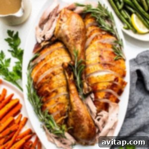 A perfectly cooked Thanksgiving turkey, expertly sliced and arranged on a elegant platter, ready for serving.