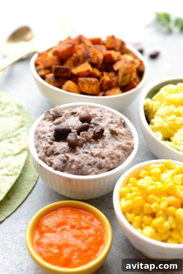 Fresh ingredients laid out on a table, including sweet potatoes, black beans, and tortillas, ready for burrito assembly.