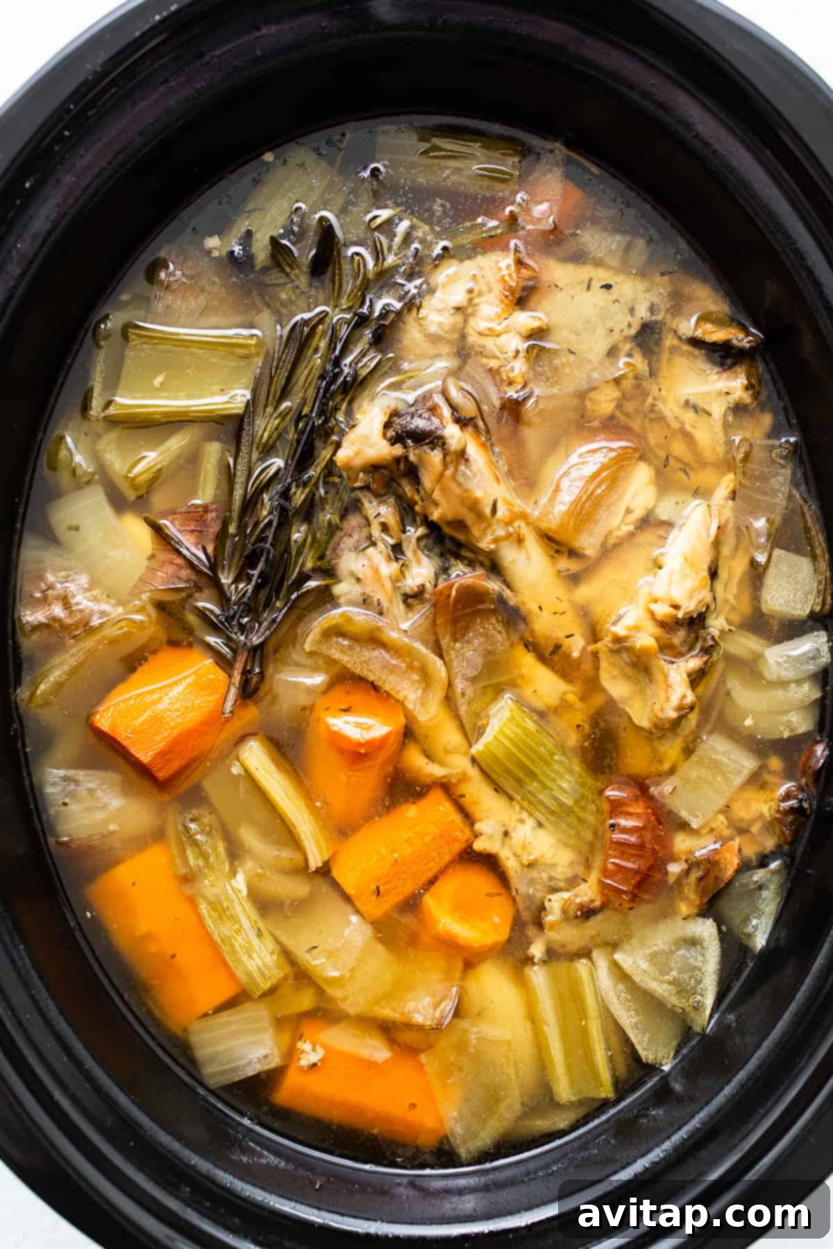 Liquid Gold Turkey Stock 8 The finished turkey stock, golden and rich, simmering gently in the slow cooker after hours of cooking.