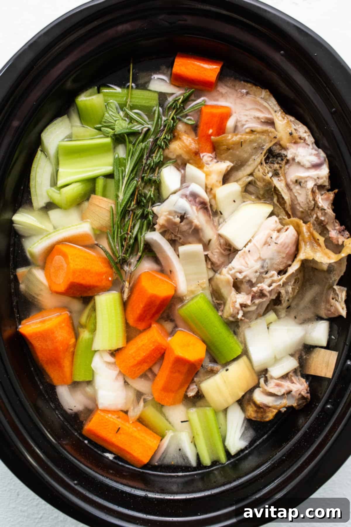 Liquid Gold Turkey Stock 5 The slow cooker filled with turkey stock ingredients, ready for a long, gentle simmer.
