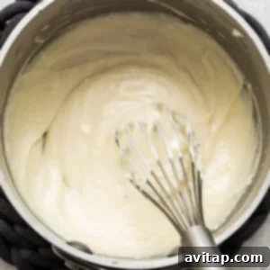 Whipping cream in a pan while preparing turkey wild rice soup.