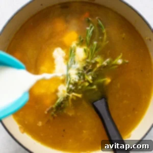 A bowl of turkey wild rice soup with milk being poured into it.