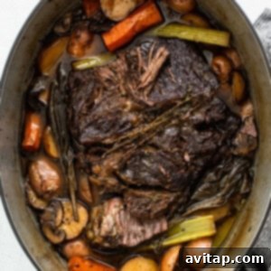 A pot full of beef, carrots and potatoes.