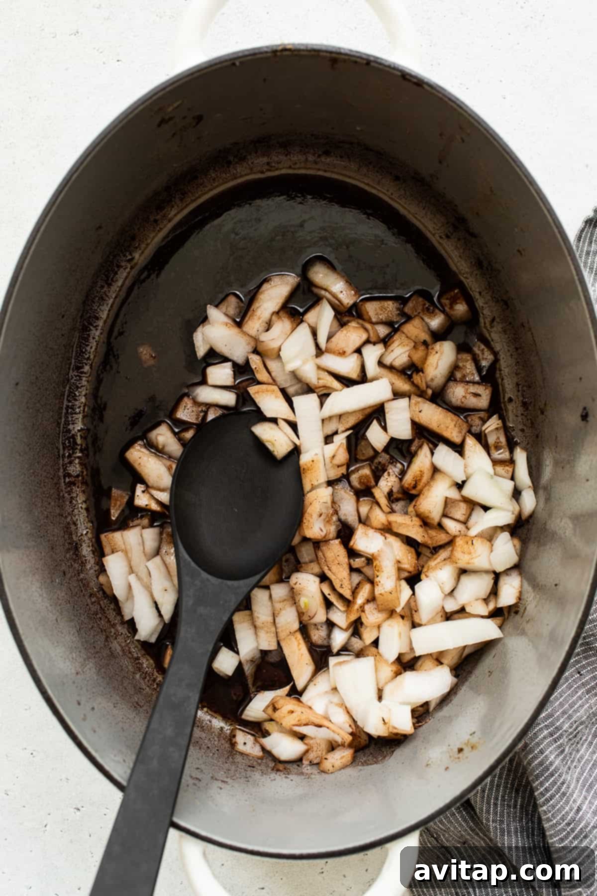 Diced onions beginning to caramelize in a Dutch oven, ready for the next step of flavor building.