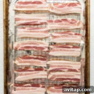 Bacon strips on a baking sheet.