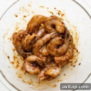 Shrimp in a glass bowl on a white surface.