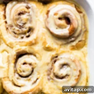 Frosted orange rolls arranged in a casserole dish, ready to serve.