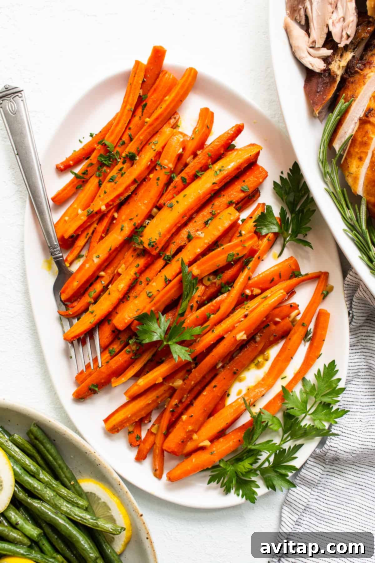 Garlic glazed carrots beautifully arranged on a plate, ready to be served, garnished with fresh herbs.