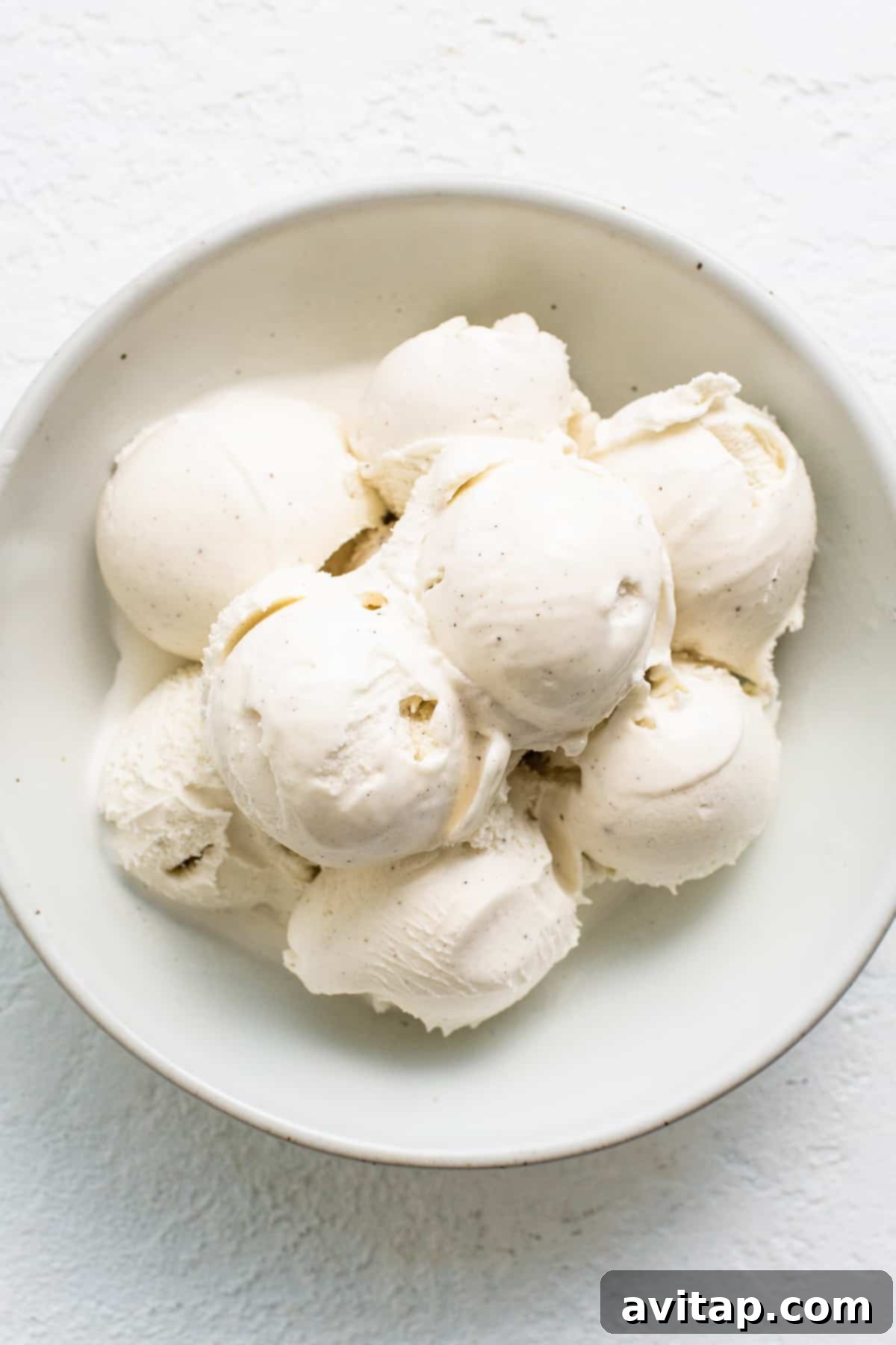Scoops of creamy eggnog ice cream in a bowl, ready to be melted and transformed into a decadent dessert.