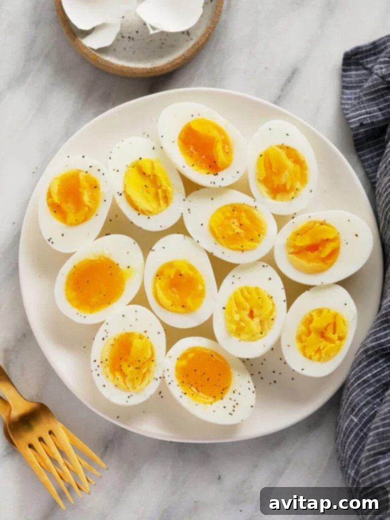 15 Delicious Breakfast Egg Recipes 8 Close-up of perfectly peeled hard-boiled eggs, showcasing their firm whites and vibrant yolks.