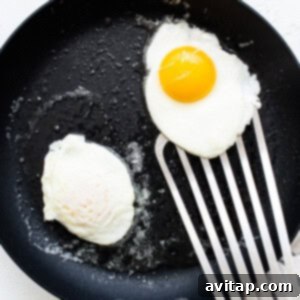 Perfectly Poached Eggs 5 Two fried eggs in a frying pan after being flipped.