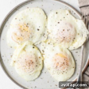 Perfectly Poached Eggs 6 Four fried eggs on a plate with a napkin, ready for serving.