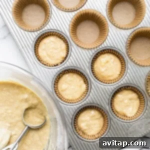 Delicious Banana Bread Muffins 5 A muffin tin filled with muffin batter and a whisk.