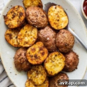 Ultimate Crispy Air Fryer Potatoes 2 Roasted potatoes on a plate with ketchup.