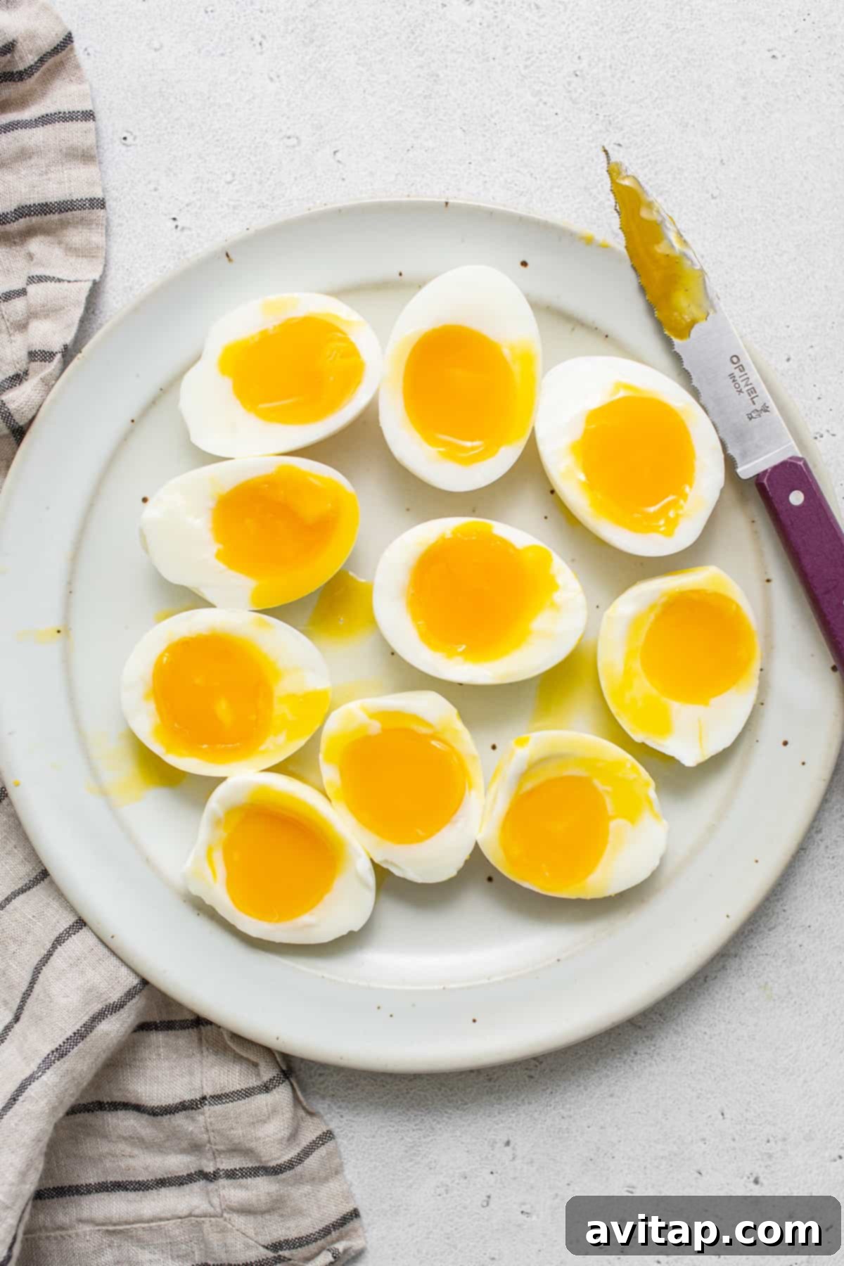 A plate of perfectly cooked soft boiled eggs, ready to be served and enjoyed with their delicious runny yolks.