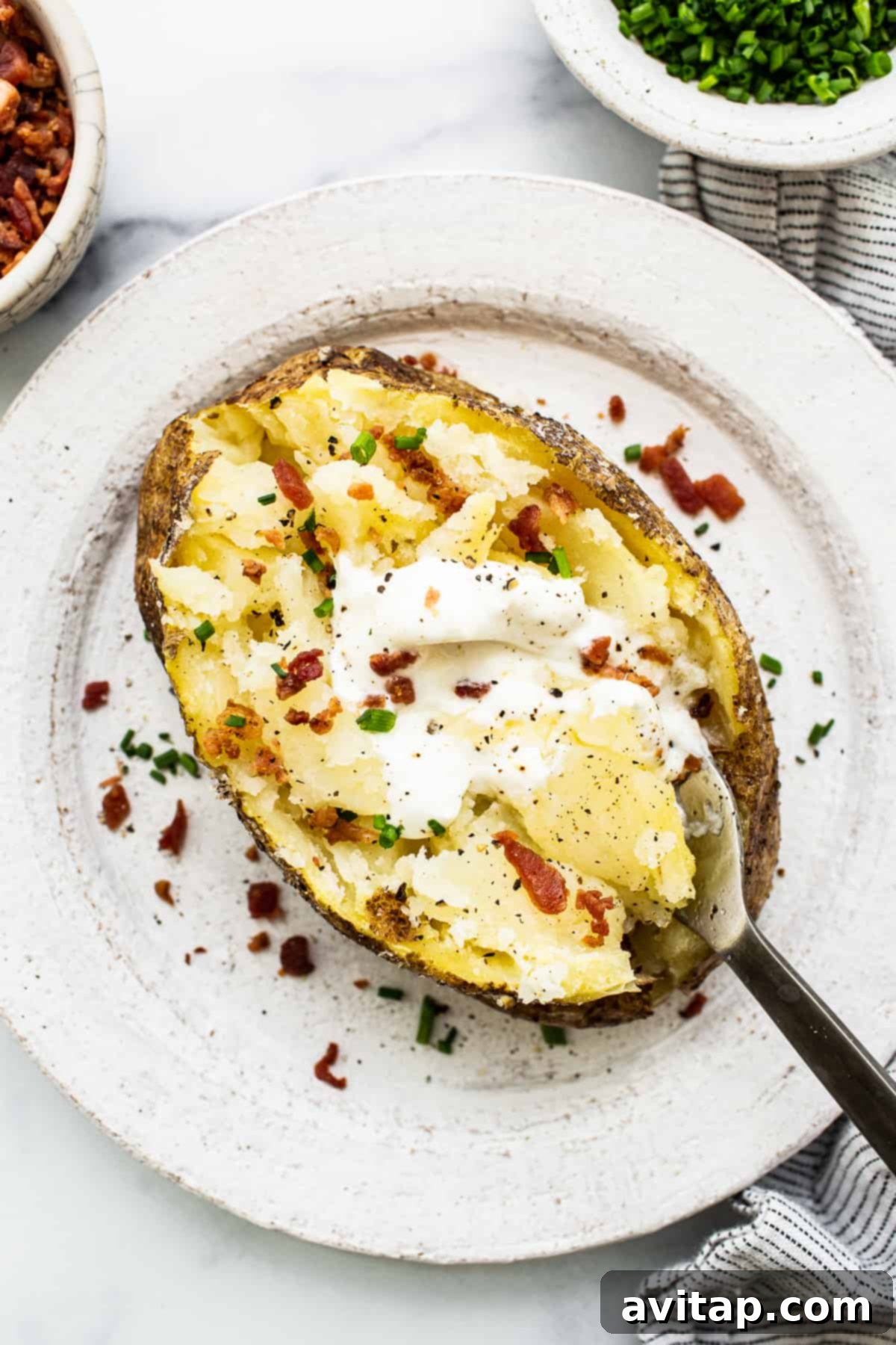 Perfect Microwave Baked Potato 2 Microwave baked potato with a variety of delicious toppings including sour cream, chives, and bacon bits.