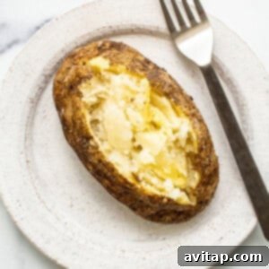 Softened baked potato being checked for doneness with a fork.