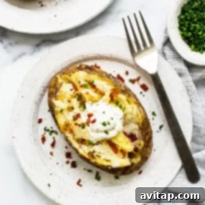 Baked potato topped with sour cream, fluffed and ready to serve.