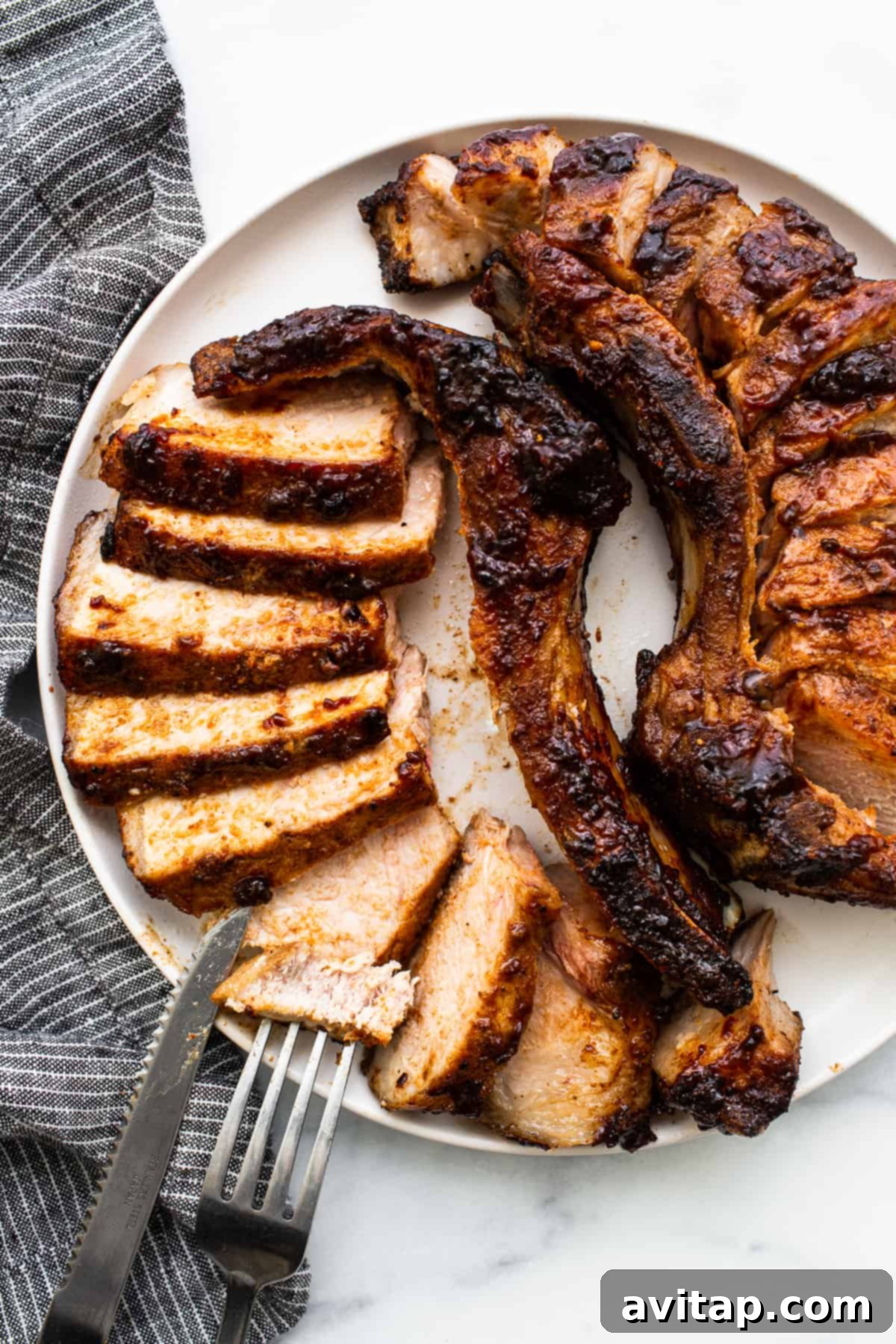 Perfectly air-fried pork chops, golden brown and juicy, on a cutting board, ready to be sliced and served.