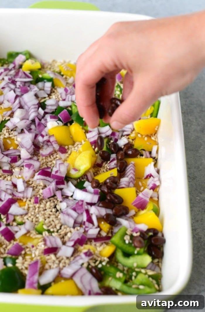 A top-down view of a bubbling chicken enchilada casserole with brown rice, showcasing melted cheese and colorful ingredients, fresh from the oven.