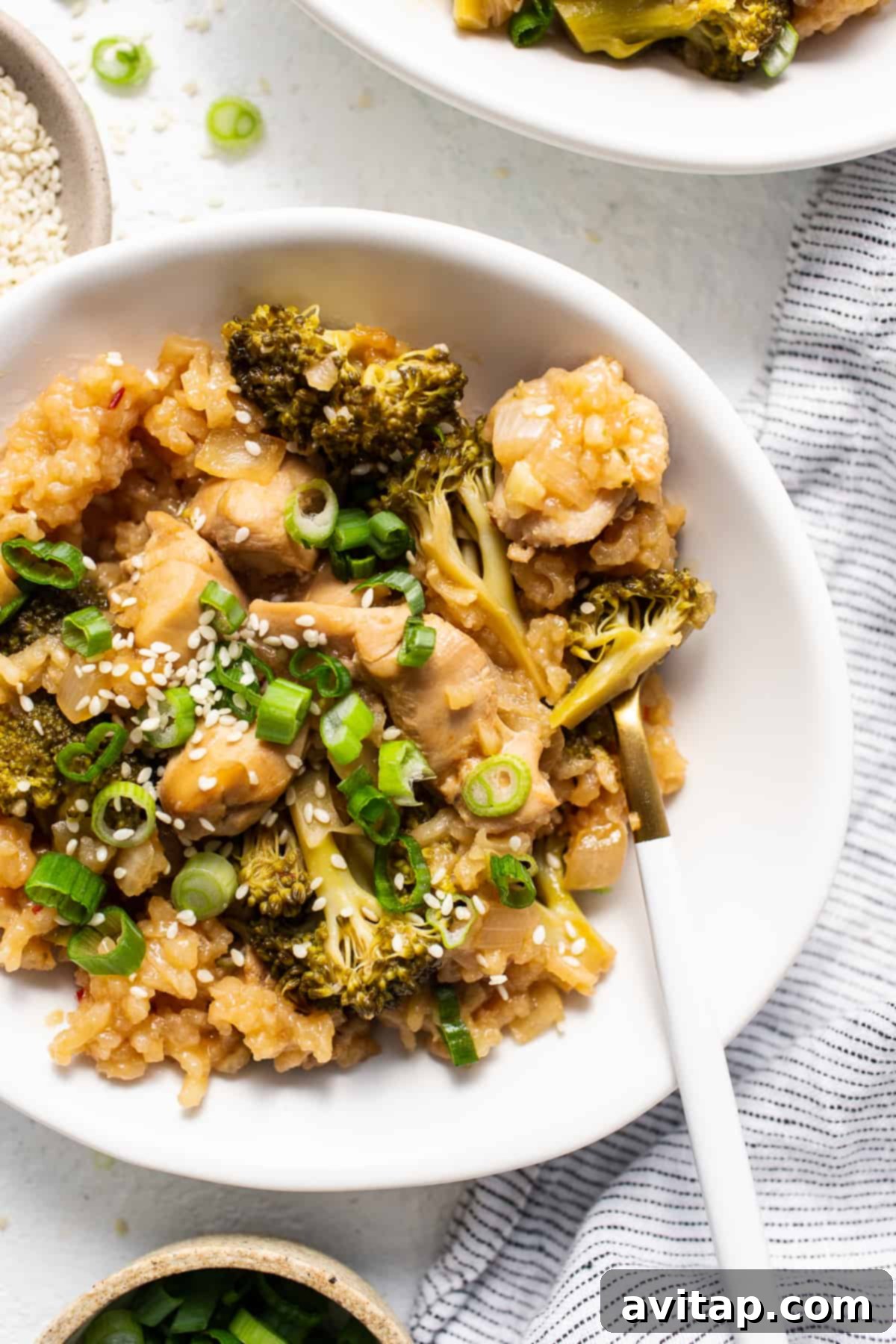 A delicious and satisfying bowl of Orange Chicken Casserole. Close-up of a serving of Orange Chicken Casserole in a bowl, showing chicken, rice, and broccoli.