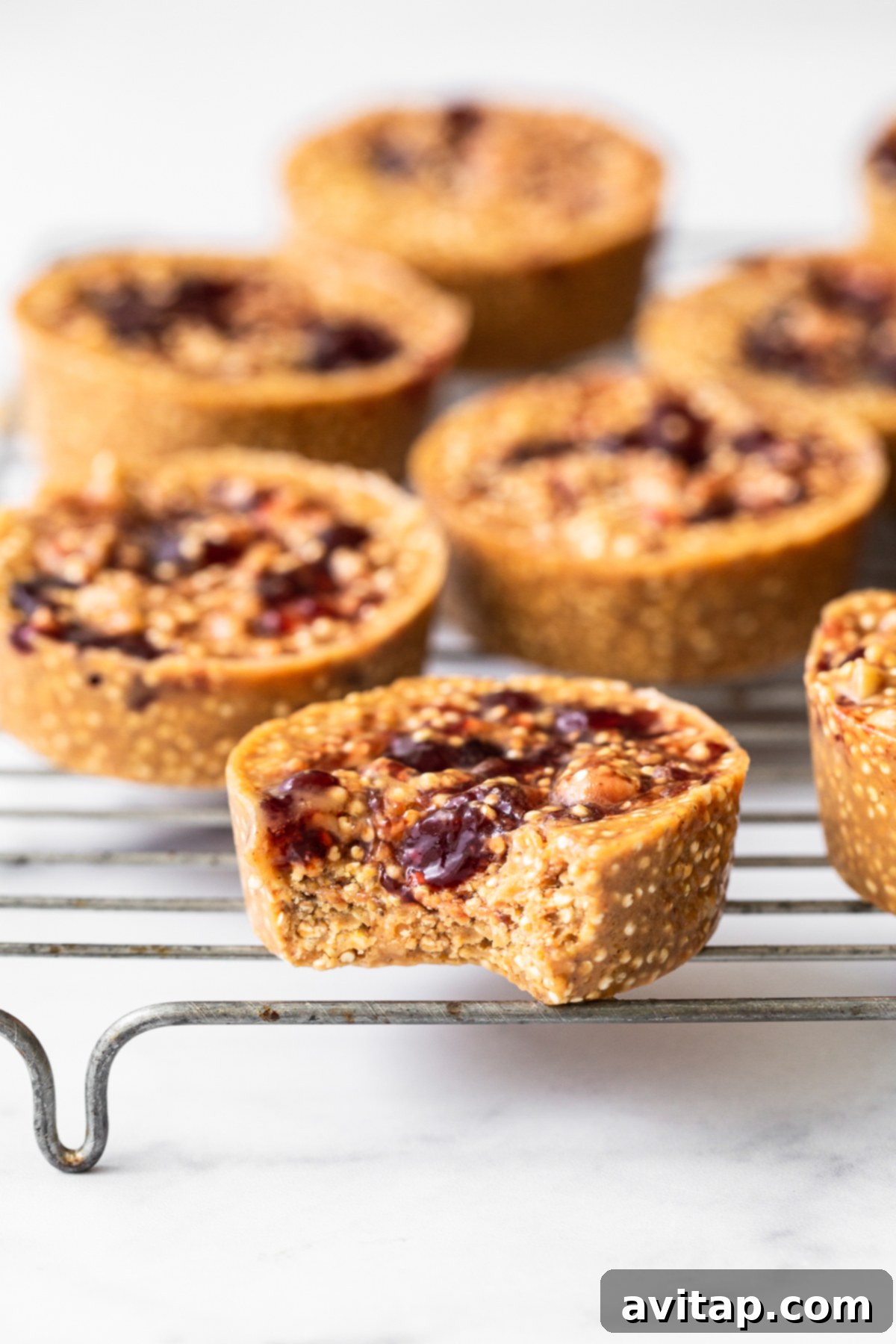 Delicious peanut butter and jelly quinoa cups displayed on a metal cooling rack, ready to be enjoyed.