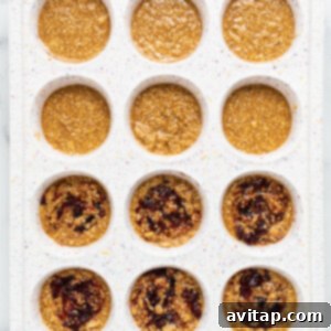 Peanut butter and jelly quinoa cups in a muffin tin with jam swirls and a sprinkle of salt.