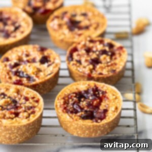 Finished peanut butter and jelly quinoa cups cooling on a metal rack after freezing.