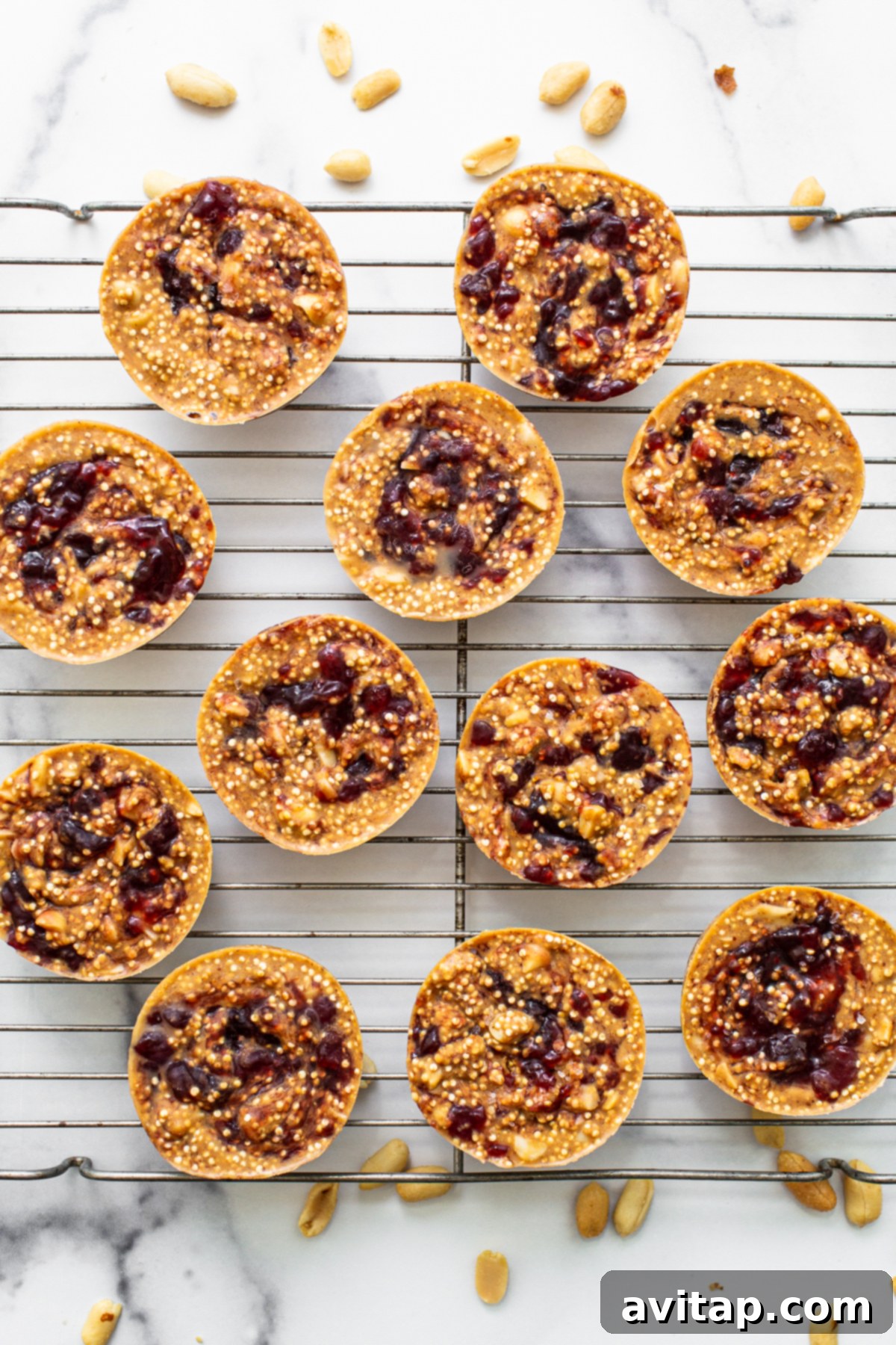 Freshly frozen peanut butter and jelly quinoa cups resting on a wire rack before being stored.