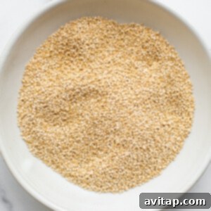 Toasted quinoa cooling in a bowl, ready to be mixed with other ingredients.