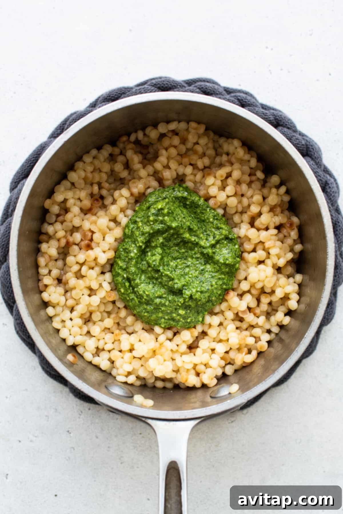 Israeli Couscous Medley 5 Cooked Israeli couscous perfectly coated in rich green kale pesto, ready to be combined with other ingredients.