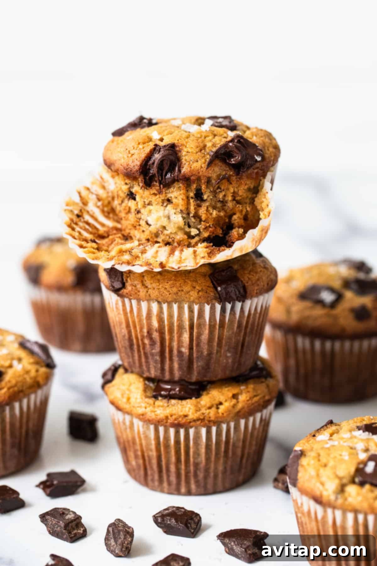 Freshly baked protein muffins with chocolate chunks, cooling on a wire rack.