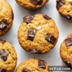 A group of chocolate chip muffins on a white surface.