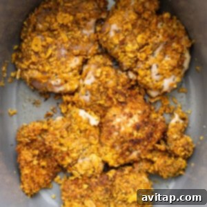 Seared, breaded chicken thighs in a hot skillet.