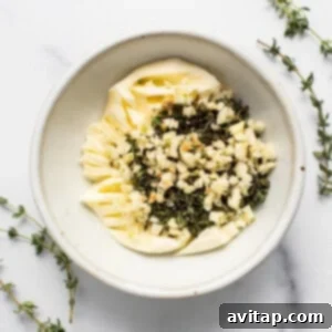 Butter, herbs, and garlic mixed in a bowl.