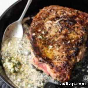 Searing a steak in a cast iron skillet with butter basting.