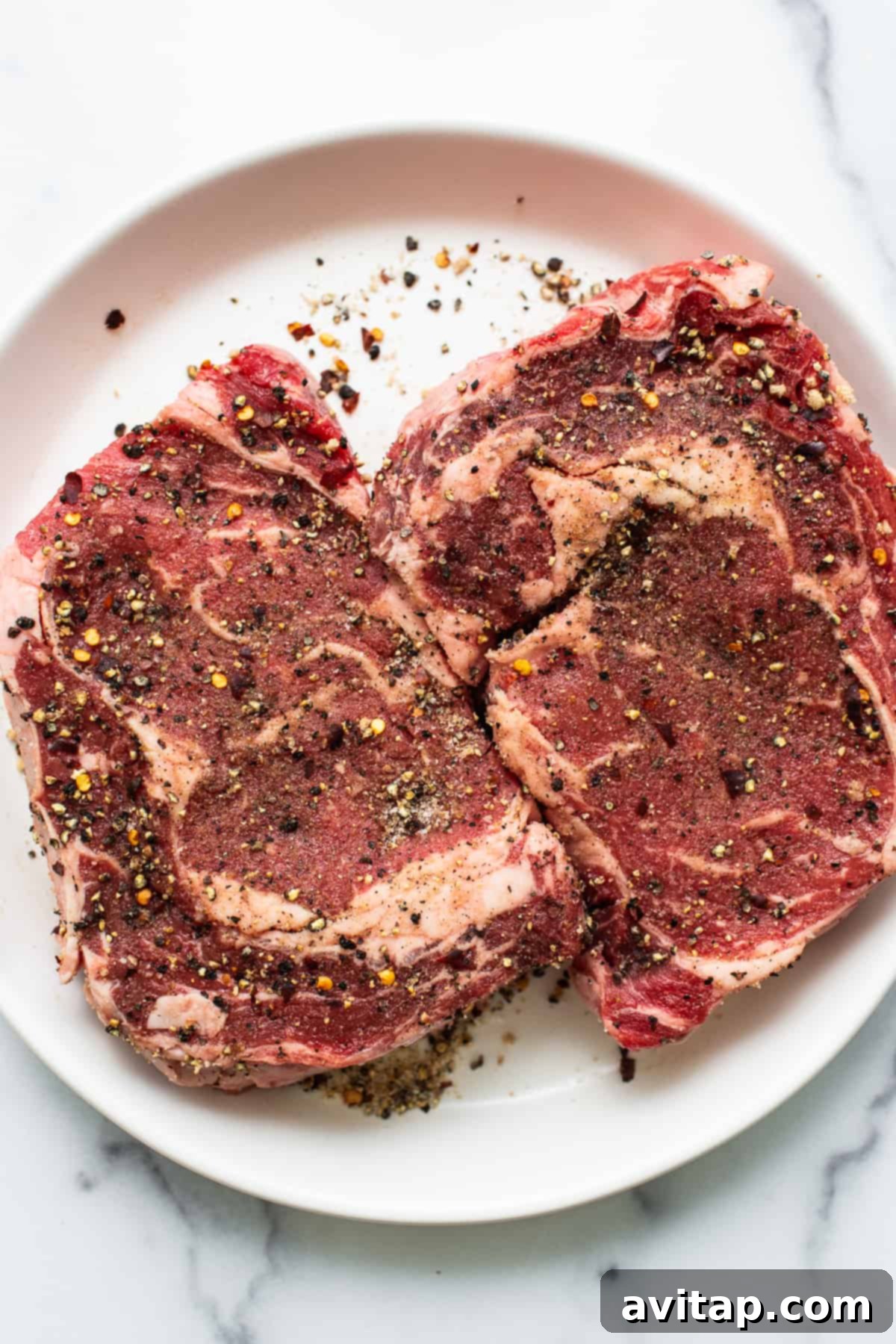 Perfect Cast Iron Steak 3 A raw steak generously coated with dry rub seasoning, ready for searing.