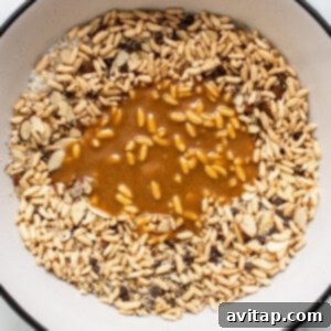 Melted brown rice syrup mixture being poured over dry ingredients.