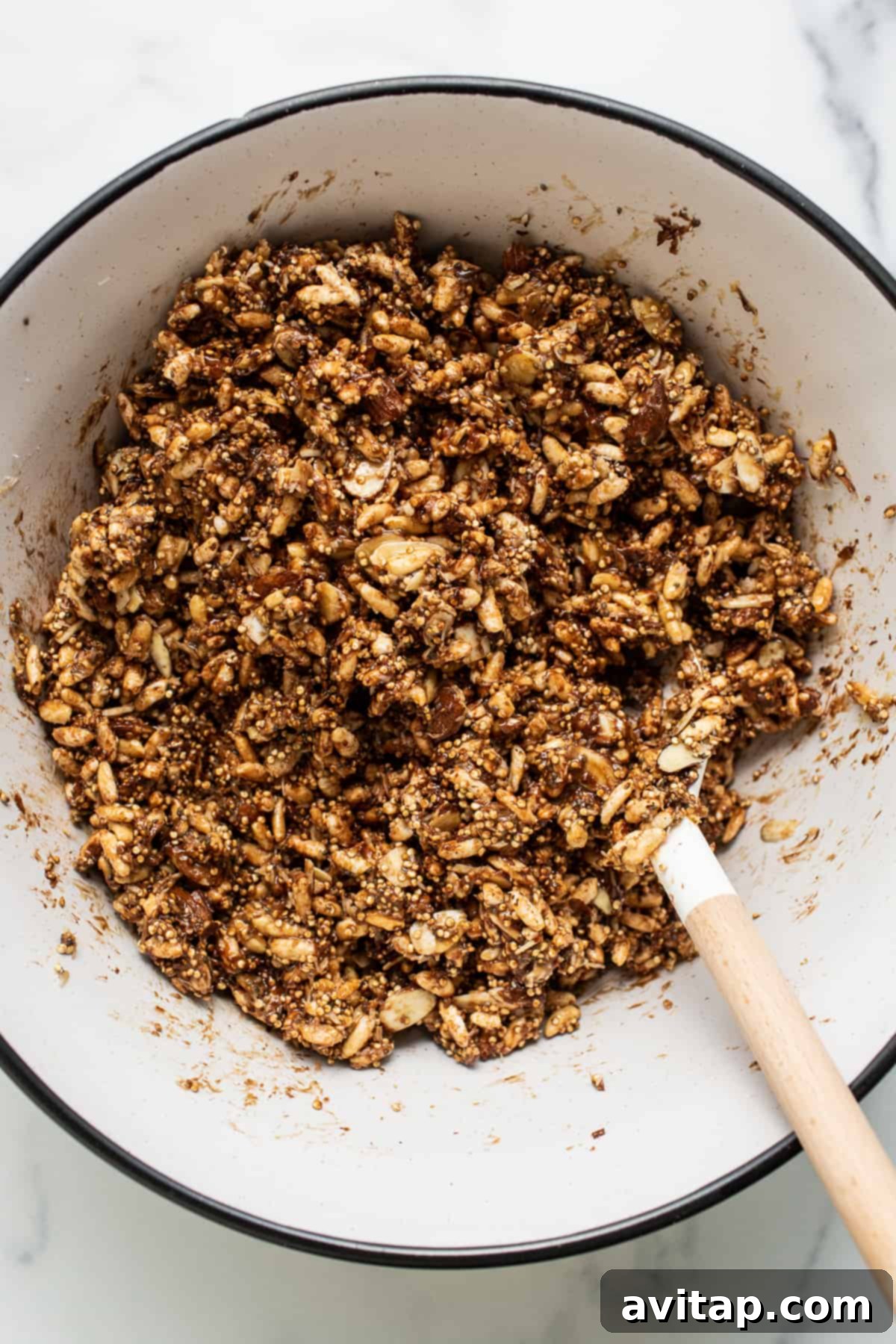 All the dry and wet bar ingredients mixed in a large bowl, with melted chocolate chips creating a rich, dark sauce.