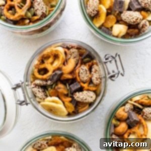 Four jars filled with nuts, seeds, and dried fruit.