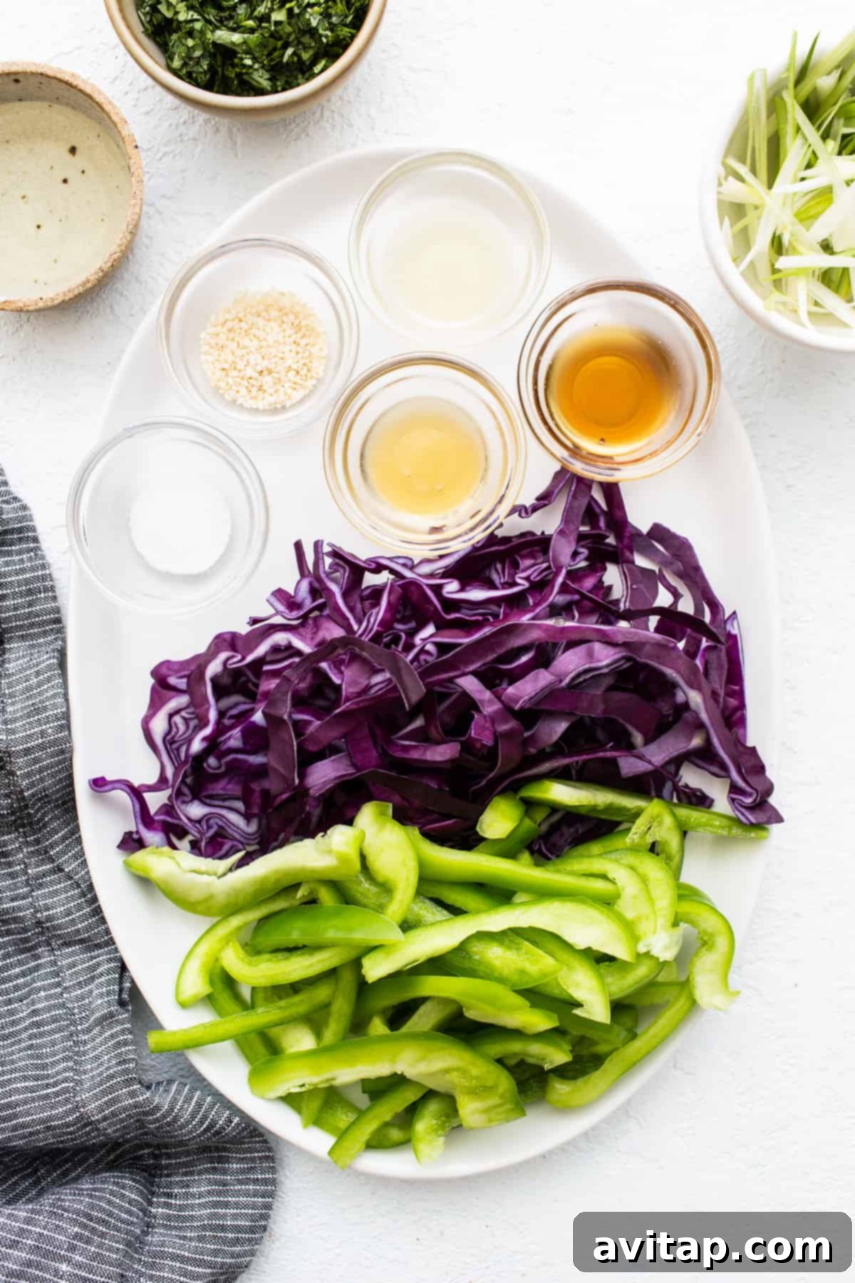 Assortment of fresh, colorful vegetables sliced and ready for coleslaw preparation, including bell peppers and cabbage.