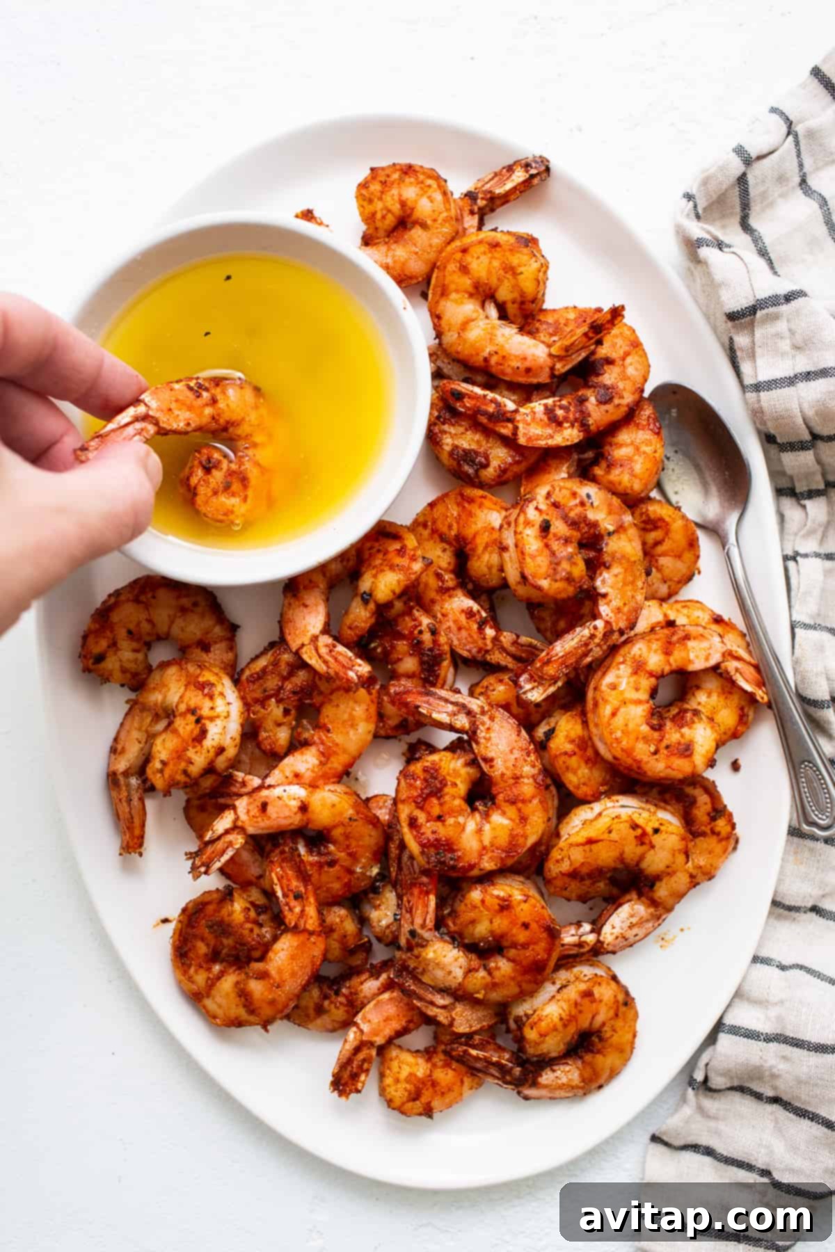 This broiled shrimp recipe is the easiest way to make perfectly juicy and crispy shrimp! Seasoned with cajun seasoning and served with a heavenly honey butter sauce. Broiled shrimp dipped in a bowl of honey butter sauce, ready to be enjoyed.
