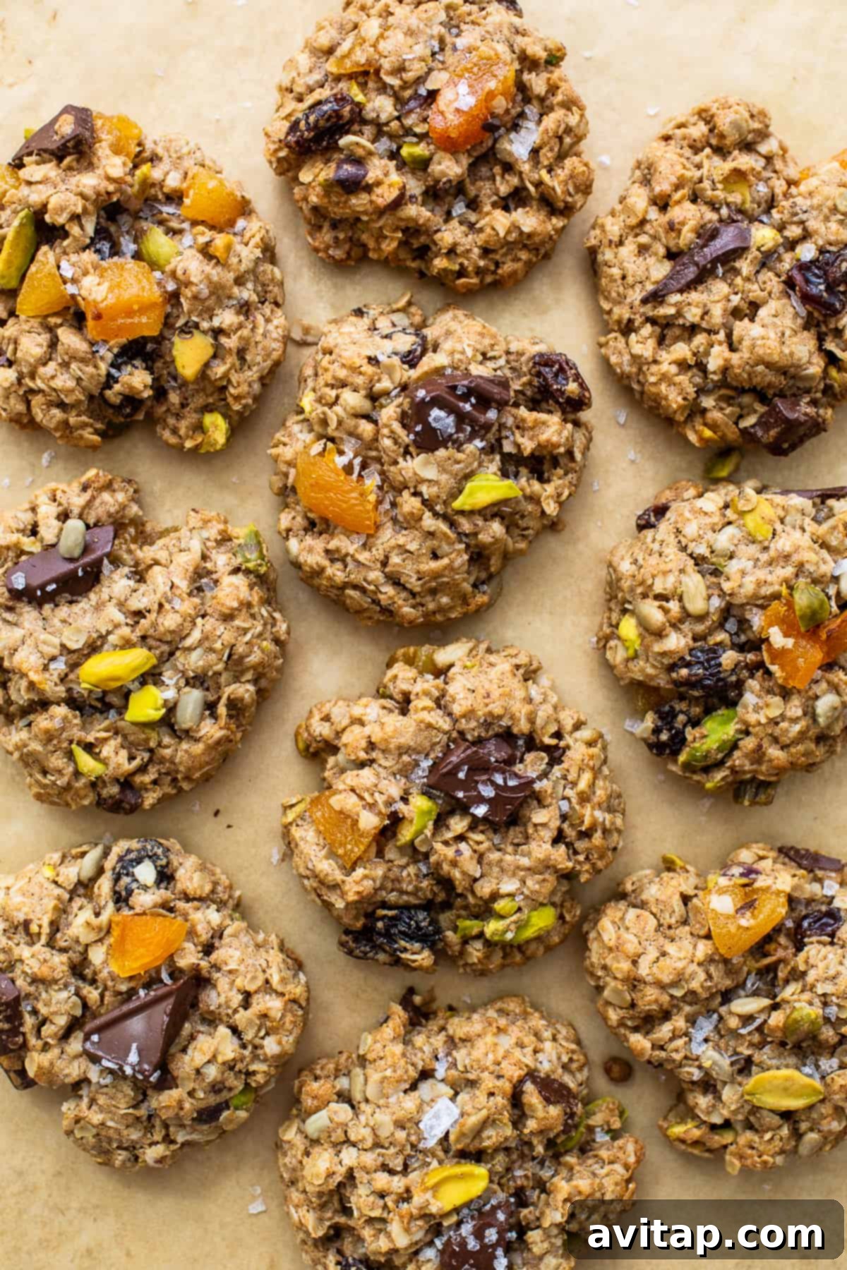 A baking sheet laden with freshly baked trail mix cookies, displaying their rich texture and abundant mix-ins.