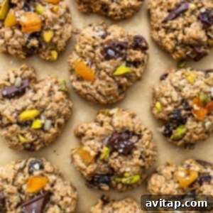 Oatmeal cookies with pistachios and dates on a baking sheet.