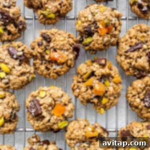 Oatmeal cookies with pistachios and nuts on a cooling rack.